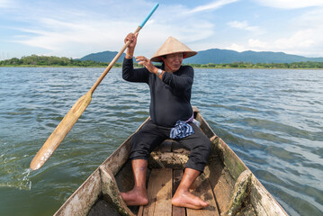 fisherman rowing boat on the river bank of summer