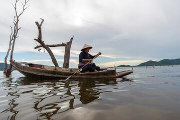 Naklejka premium fisherman rowing boat on the river bank of summer