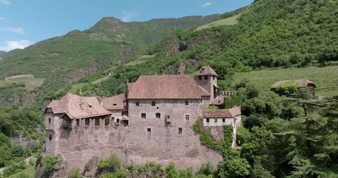 Aerial view of Bolzano Castle in the Alps of Italy. Old fortress with high walls on the mountain, tourism and travel in Europe. High quality 4k footage