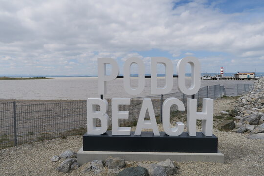 Podersdorf, Burgenland, &Ouml;sterreich - 04 21 2024: Podo Beach steht auf einem Schild nahe des Stegs in Podersdorf am Neusiedler See.