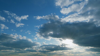Obraz premium Majestic amazing sky. Sunburst or sun rays light beam through the clouds as fantastic background. Timelapse.