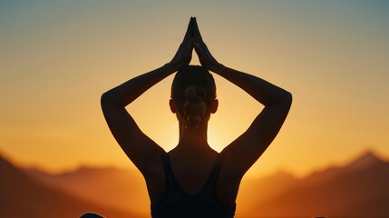 Yoga instructor's back during sunrise pose, mountains backdrop