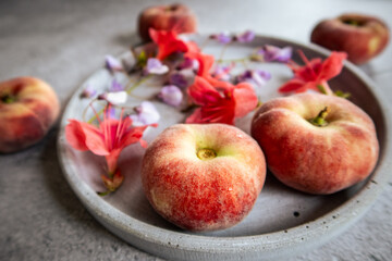 close up of a fresh peach with flowers and other peaches in the background
