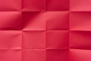 folded red paper background (unfolded revealing a pattern of creases or blocks)