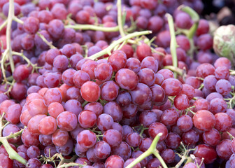 Close up on piles of fresh ripe purple grapes sale at farmers market.. View from above.