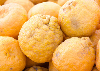 Close up on pile of fresh ripe Mandarin Oranges for sale at farmers market.