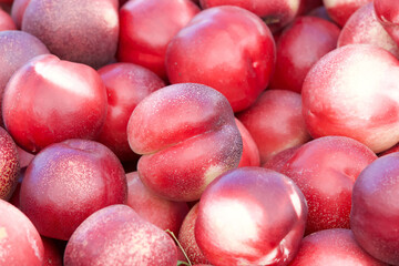 Close up on pile of fresh ripe white nectarines sale at farmers market.. View from above