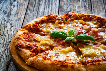 Pizza Serrano with cured ham, mozzarella cheese and mushrooms on wooden table
