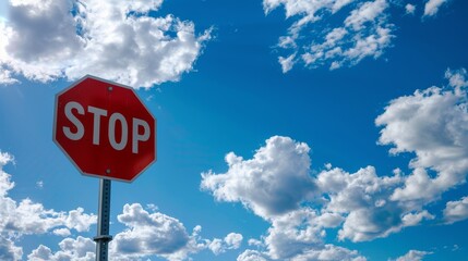 Stop sign under a blue sky with scattered clouds