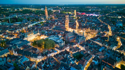 Enchanting aerial view of Bruges' historic old town captured by a drone at night! The illuminated medieval architecture, winding canals, and charming cobblestone streets create a magical and captivati