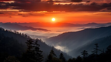 Obraz premium A captivating sunrise over a misty mountain range with layers of mountains and a dense forest in the foreground, capturing the beauty of nature.