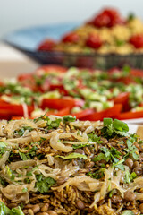 A lentil and rice dish ready to eat, with other salads defocused behind