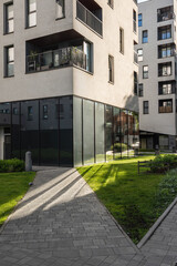  A fragment of a residential building and the surrounding area with landscaping