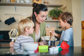 Baking, family and mother with children in kitchen with ingredients for learning, bonding and recipe. Happy, home and mom with young boys with flour to bake cookies, biscuits and treats together