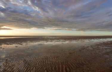 Low clouds over a Old Hunstanton beach at sunset