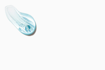 Smear of cosmetic texture blue gel on light background
