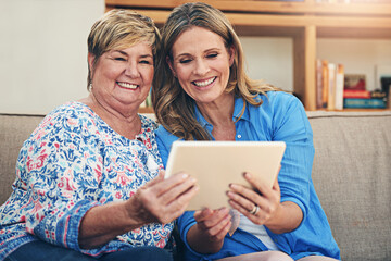 Senior mother, daughter and happy with tablet on sofa in home for digital photo album and memories. Family parent and women with smile for ebook or streaming comedy for entertainment, fun and bonding