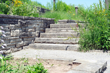 Luxury landscaping with natural stone retaining wall and coping, wide steps and landing.