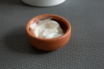 A closeup view of a clay condiment cup of dairy-free sour cream.