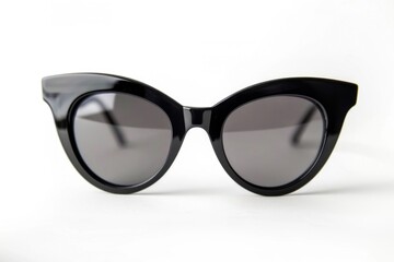 Fototapeta premium A pair of classic black cat-eye sunglasses with dark lenses are shown on a white background