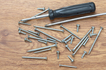 screwdriver and screws on wood. 