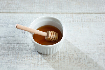 A view of a honey dipper in a bowl of honey.