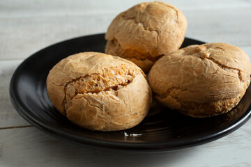 A view of gluten-free rolls on a black plate.