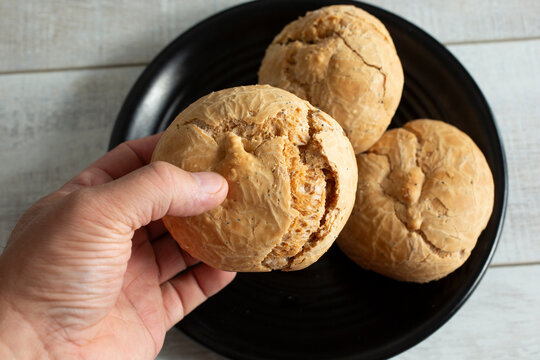 A top down view of a hand holding a gluten-free bun.