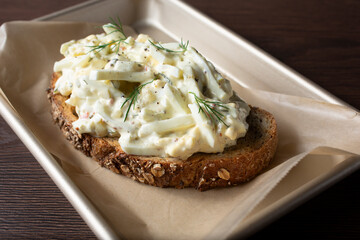 A view of an open faced egg salad sandwich.