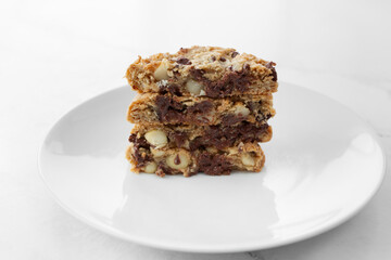 A view of a sliced stack of cookies, featuring chocolate chip and macadamia nuts.