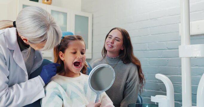 Healthcare, pediatric dentist and girl with mirror for checkup, oral examination and consultation. Hospital, mom and little child with orthodontist for teeth surgery, trust and discussion in clinic