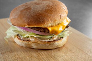 A closeup view of a cheeseburger.