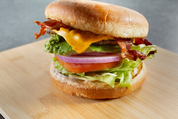 A closeup view of a bacon avocado cheeseburger.