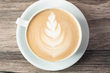 A top down view of a latte coffee drink, featuring latte art.