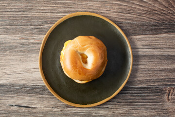 A top down view of an egg and cheese bagel sandwich.