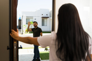 Neighbors in a suburban community happily greeting each other outside their homes on a sunny day, highlighting a strong sense of friendship and connection