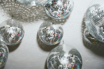 A view of several disco balls hanging on the ceiling.