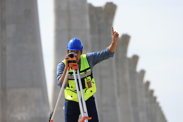 Clever explorer male survey engineer with a surveyor's telescope to explore the construction area...