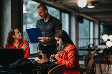 Young business entrepreneurs discussing ideas in a modern office setting. Collaborative and productive work environment with laptops and documents.