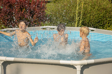 A boy with wet hair is enthusiastically swimming in a pool, giving a thumbs-up gesture. Another...