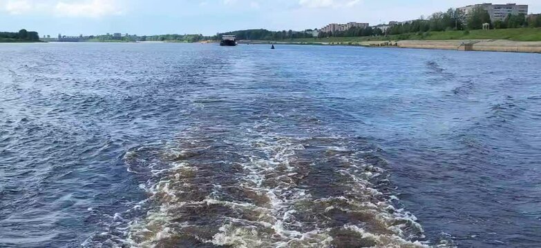 Swirling blue waves astern of a moving ship