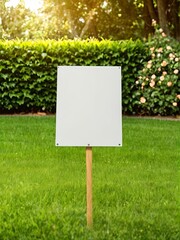 Mock up Blank square sign on stake placed on green grass with lush hedges in the background under a bright sky.