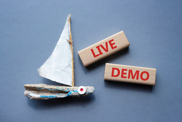 Live Demo symbol. Concept word Live Demo on wooden blocks. Beautiful grey background with boat....