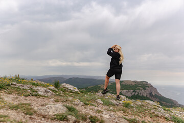 Obraz premium A woman stands on a rocky hillside, looking out over the landscape