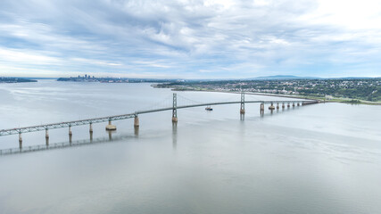 Fototapeta premium Aerial view of the old Orlean's Island Bridge (Quebec, Canada). View of Quebec city in background.