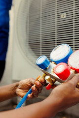 Close up of competent mechanic holding manometers used for checking hvac system refrigerant. Expert...
