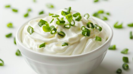 Bowl of sour cream topped with chopped green onions, close-up. Culinary ingredients and fresh dairy concept