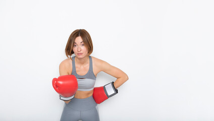 Young and attractive woman in boxing gloves posing isolated on white background	