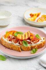 Sandwich with grilled peach, ham, cream cheese and basil. Delicious healthy snack. Selective focus