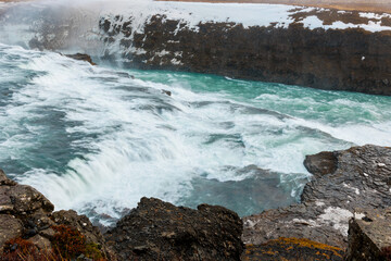 Iceland gullfoss cascade impressive river flow surrounded by snowy slopes and wildlife. Amazing massive streams of water forming cascade and famous nordic landscape in Europe.